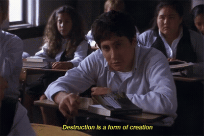 A Man Sits At A Desk In A Classroom With The Words " Destruction Is A Form Of Creation " Above Him GIF