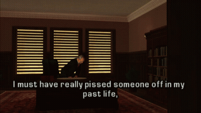A Man Sits At A Desk In A Dark Room With The Words " I Must Have Really Pissed Someone Off In My Past Life " GIF
