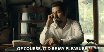A Man Sits At A Desk Talking On A Phone With The Words Of Course It 'D Be My Pleasure GIF