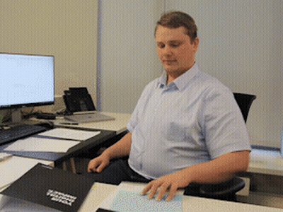 A Man Sits At A Desk With A Folder On It That Says ' Microsoft Teams ' GIF