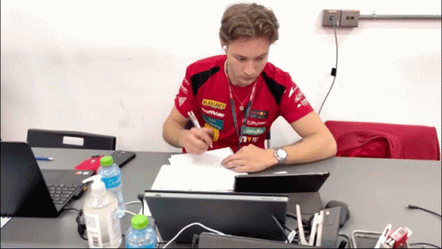 A Man Sits At A Desk With A Laptop And A Bottle Of Coca Cola In Front Of Him GIF