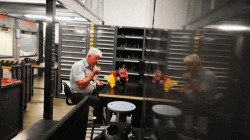 A Man Sits At A Table Eating Chips And Drinking A Coca Cola GIF
