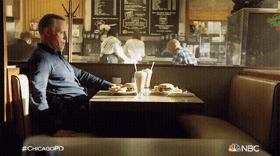 A Man Sits At A Table In A Diner With A Nbc Logo In The Corner GIF