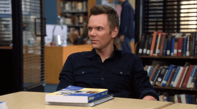 A Man Sits At A Table With A Book On Top Of It That Says ' Biology ' GIF
