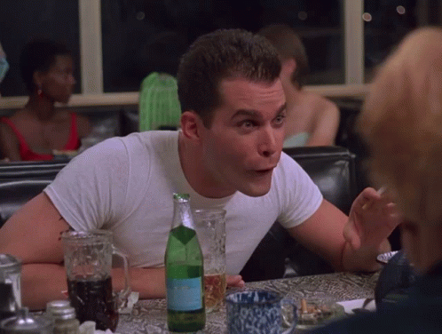 A Man Sits At A Table With A Bottle Of Aquafina GIF
