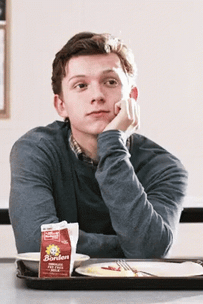 A Man Sits At A Table With A Carton Of Borden Milk On It GIF