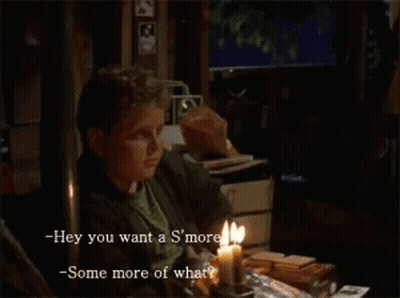 A Man Sits At A Table With A Lit Candle And Says Hey You Want A S'more -Some More Of What GIF