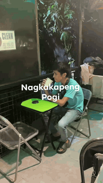 A Man Sits At A Table With A Sign That Says Clean As You Go Behind Him GIF