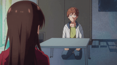 A Man Sits At A Table With A Woman Looking At Him GIF
