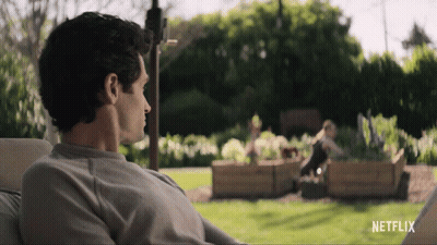 A Man Sits In A Chair In Front Of A Netflix Sign GIF