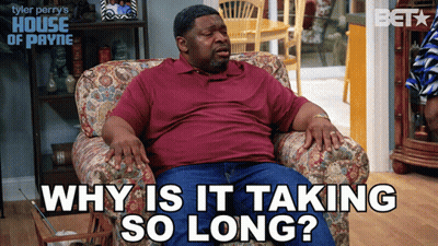 A Man Sits In A Chair With The Words " Why Is It Taking So Long " Above Him GIF