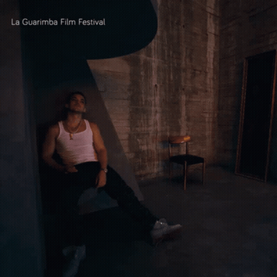A Man Sits In A Dark Room With La Guarimba Film Festival Written On The Top GIF