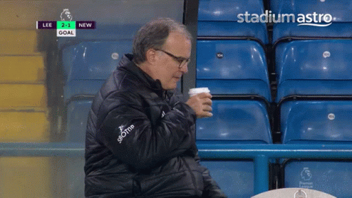 A Man Sits In A Stadium Watching A Soccer Game With Stadiumastro On The Bottom Left GIF