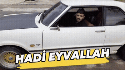 A Man Sits In A White Car With The Words Hadi Eyvallah On The Side GIF