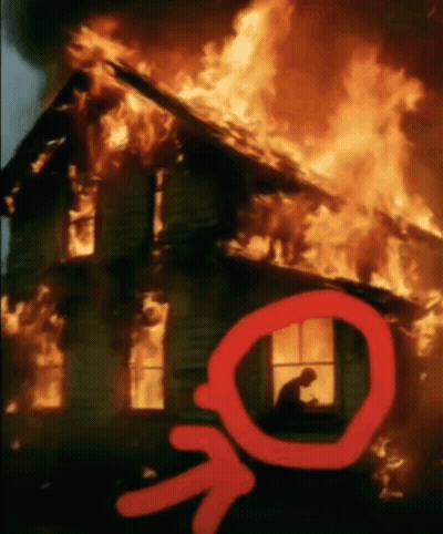 A Man Sits In A Window Of A Burning House With An Arrow Pointing To It GIF
