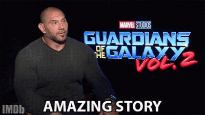 A Man Sits In Front Of A Guardians Of The Galaxy Vol 2 Sign GIF