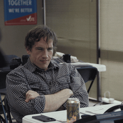 A Man Sits In Front Of A Sign That Says Together We Are Better GIF