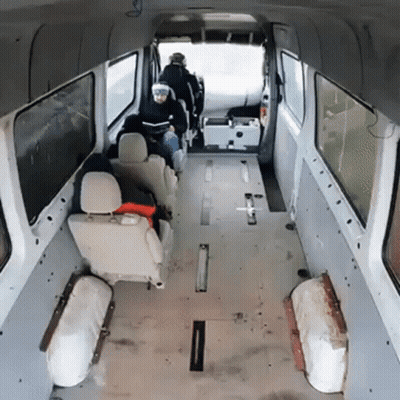 A Man Sits In The Back Of A Van Looking At His Phone GIF