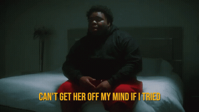 A Man Sits On A Bed With The Words " Can 'T Get Her Off My Mind If I Tried " Above Him GIF