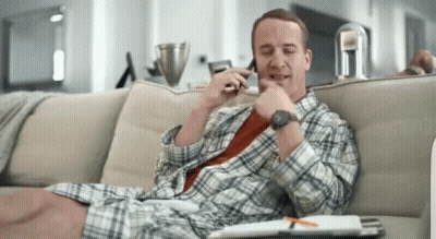 A Man Sits On A Couch Talking On A Cell Phone GIF