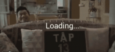 A Man Sits On A Couch With A Sign That Says Tap 13 GIF