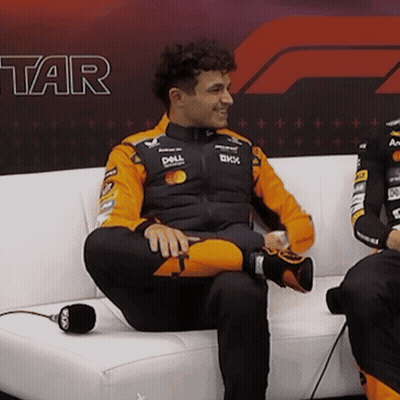 A Man Sits On A Couch With His Legs Crossed And A Dell Jacket On GIF