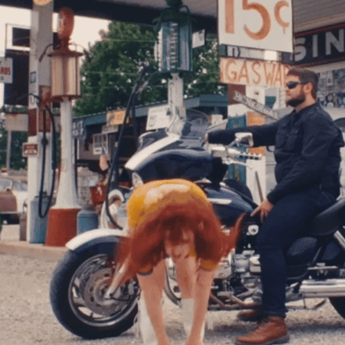 A Man Sits On A Motorcycle Next To A Gas Station GIF