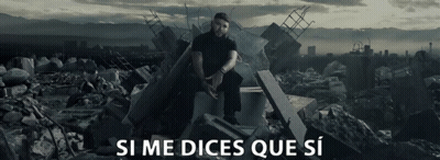 A Man Sits On A Pile Of Rubble With The Words Si Me Dices Que Si Written Below Him GIF