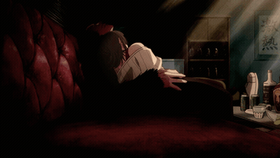 A Man Sits On A Red Couch In A Dark Room With Chinese Writing On The Wall Above Him GIF