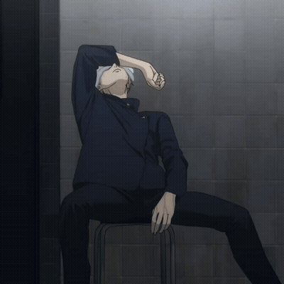 A Man Sits On A Stool With His Head Down GIF