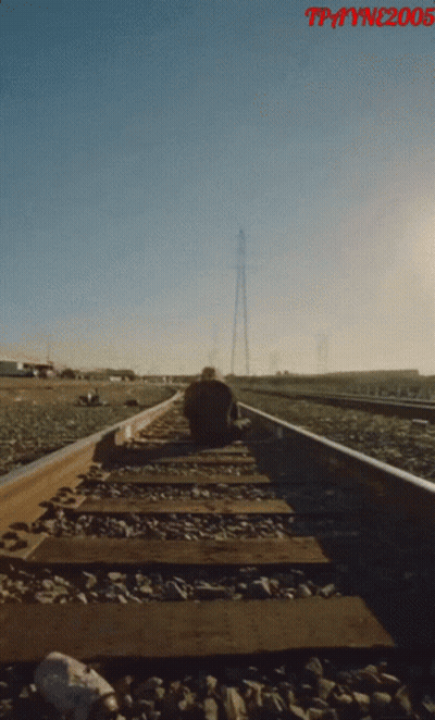A Man Sits On A Train Track With The Year 2005 On The Bottom Right GIF