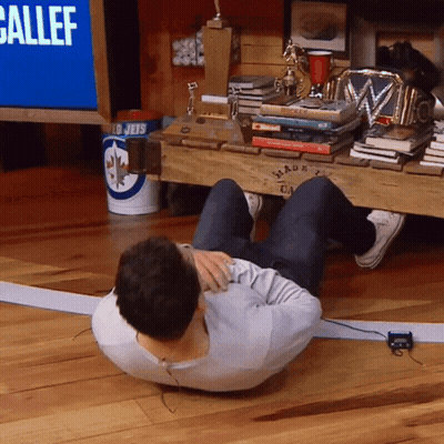 A Man Sits On The Floor In Front Of A Sign That Says " Ballef " GIF