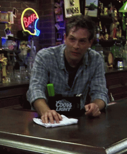 A Man Sitting At A Bar With A Coors Light Container On The Counter GIF