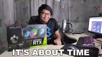 A Man Sitting At A Desk Holding A Box Of A Geforce Rtx Card GIF