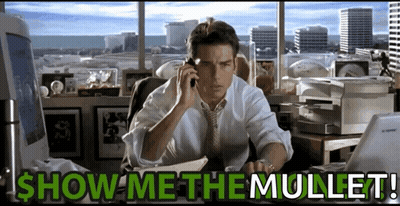 A Man Sitting At A Desk Talking On A Cell Phone With The Words Show Me The Mullet Written Below Him GIF