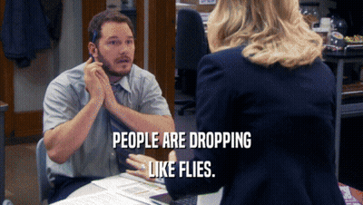 A Man Sitting At A Desk Talking To A Woman With The Words People Are Dropping Like Flies Above Him GIF