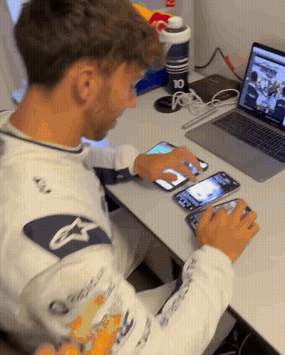 A Man Sitting At A Desk Using A Laptop And A Phone With The Number 10 On It GIF