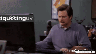 A Man Sitting At A Desk With A Computer And A Sign That Says Iquetinguv GIF