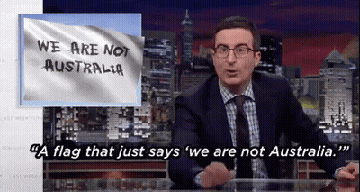 A Man Sitting At A Desk With A Flag That Says We Are Not Australia On It GIF