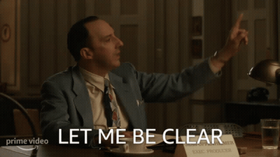 A Man Sitting At A Desk With A Sign That Says Exec Producer On It GIF