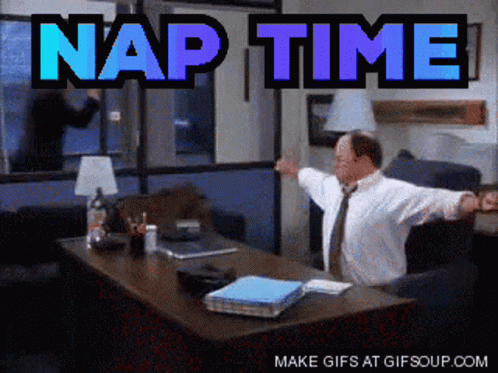 A Man Sitting At A Desk With His Arms Outstretched And The Words Nap Time Behind Him GIF