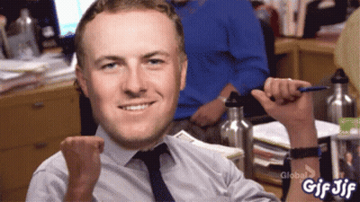 A Man Sitting At A Desk With His Fist In The Air And A Gif Jif Written On The Bottom Right GIF