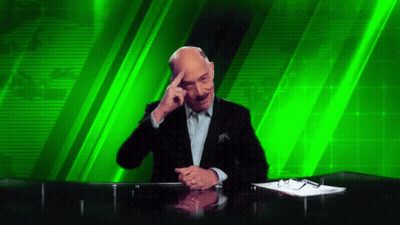 A Man Sitting At A Desk With His Hand On His Forehead GIF