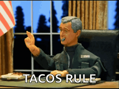 A Man Sitting At A Desk With Tacos Rule Written On The Screen GIF