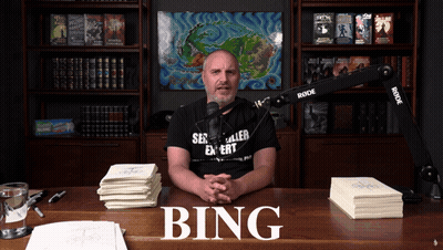A Man Sitting At A Desk With The Word Bing On The Top GIF