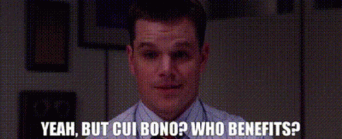 A Man Sitting At A Desk With The Words Yeah But Cui Bono Who Benefits Written Below Him GIF