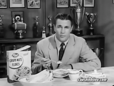 A Man Sitting At A Table Eating Grape Nuts Flakes Cereal GIF