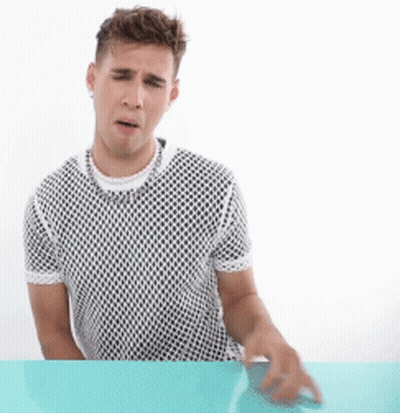 A Man Sitting At A Table Wearing A Mesh Shirt GIF