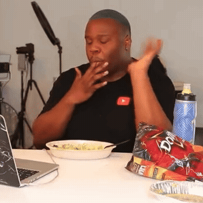A Man Sitting At A Table With A Bag Of Doritos Next To Him GIF