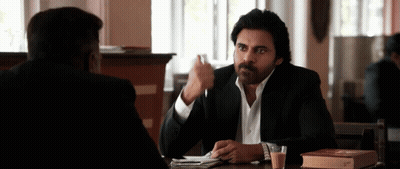 A Man Sitting At A Table With A Book On It GIF